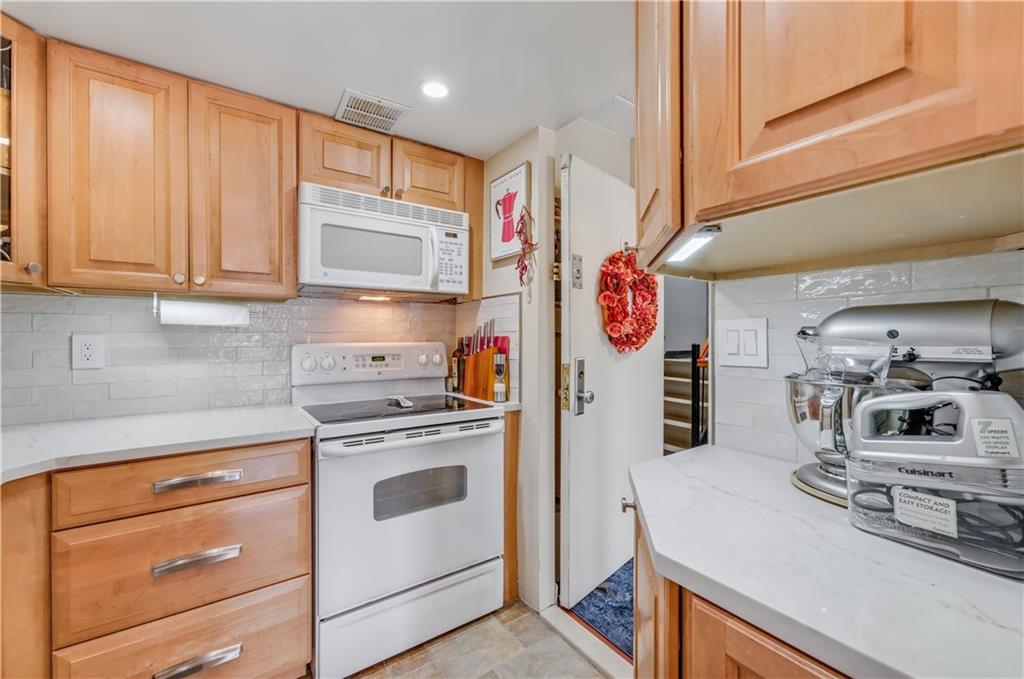 9977 Shore Road, Unit 11D Brooklyn, NY 11209 - Photo 12 of 27 a kitchen with stainless steel appliances granite countertop a sink and a stove