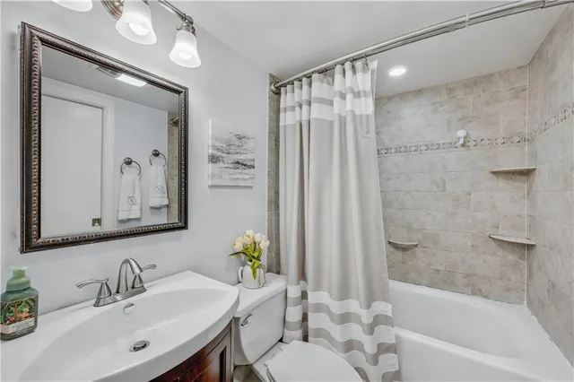 a bathroom with a sink mirror toilet and bathtub