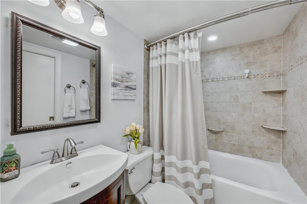 9977 Shore Road, Unit 11D Brooklyn, NY 11209 - Photo 16 of 27 a bathroom with a sink mirror toilet and bathtub