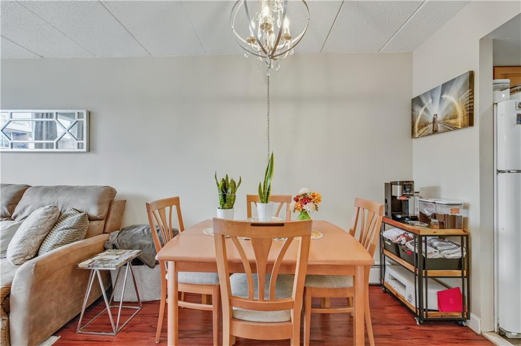 9977 Shore Road, Unit 11D Brooklyn, NY 11209 - Photo 6 of 27 a view of a dining room with furniture wooden floor and chandelier