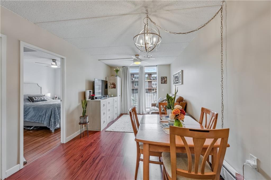 9977 Shore Road, Unit 11D Brooklyn, NY 11209 - Photo 8 of 27 a view of a dining room with furniture wooden floor and chandelier