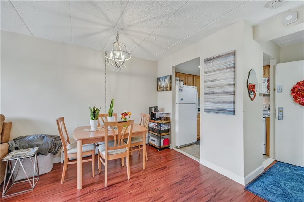 9977 Shore Road, Unit 11D Brooklyn, NY 11209 - Photo 10 of 27 a view of a dining room with furniture wooden floor and a chandelier