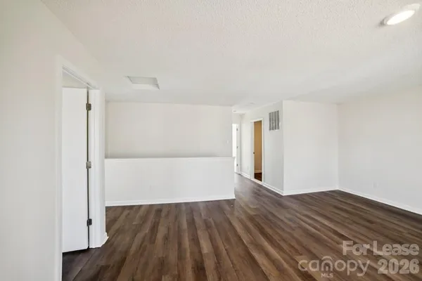 a view of a room with wooden floor