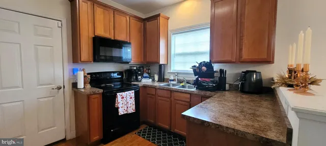 a kitchen with stainless steel appliances granite countertop a sink stove and cabinets