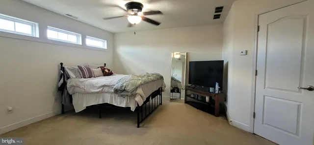 a bedroom with a bed and a flat tv screen on the dresser