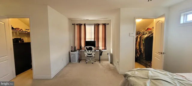 a view of a bedroom with a bed and a window