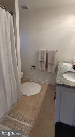 a bathroom with a granite countertop sink and toilet
