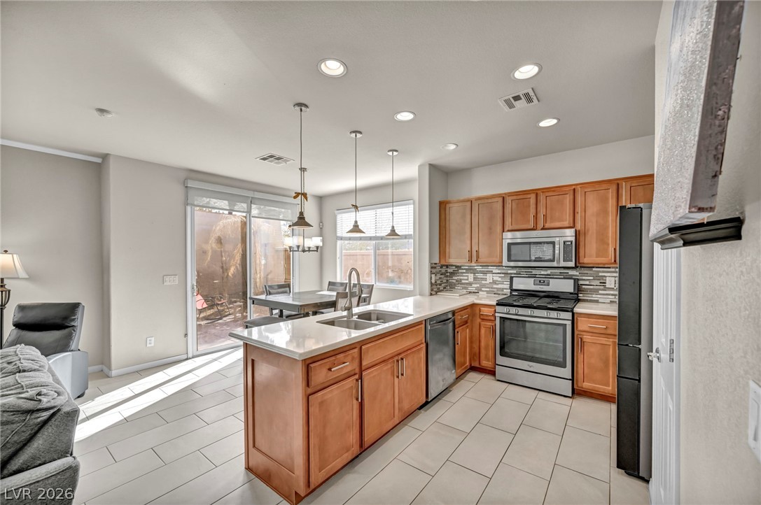 389 Fringe Ruff Drive Las Vegas, NV 89148 - Photo 3 of 53 Warm wood cabinetry and tile flooring anchor this functional kitchen with sliding glass doors.