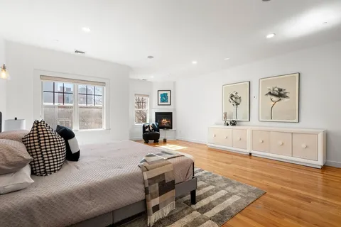 a spacious bedroom with a bed and wooden floor