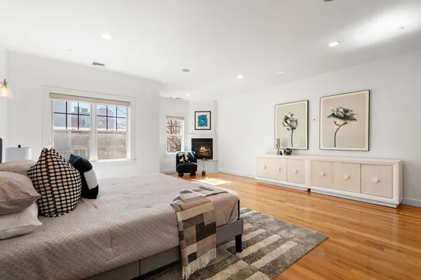 a spacious bedroom with a bed and wooden floor