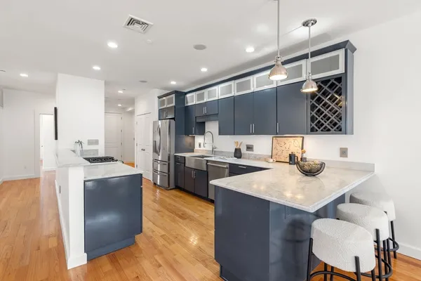 a kitchen with stainless steel appliances granite countertop a sink refrigerator and cabinets