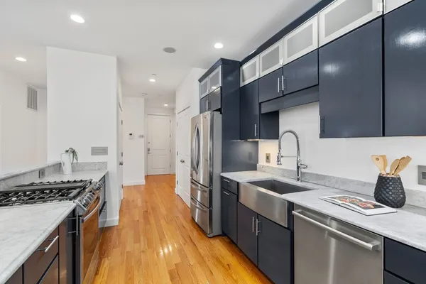 a kitchen with kitchen island a sink stove and refrigerator