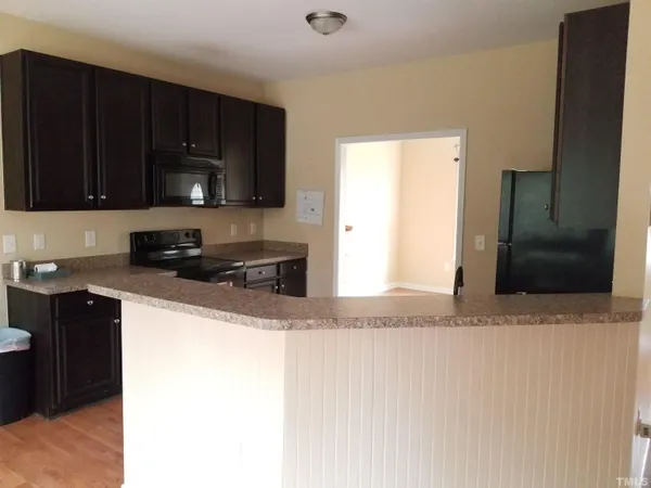 a kitchen with stainless steel appliances granite countertop a refrigerator a stove a sink and a microwave