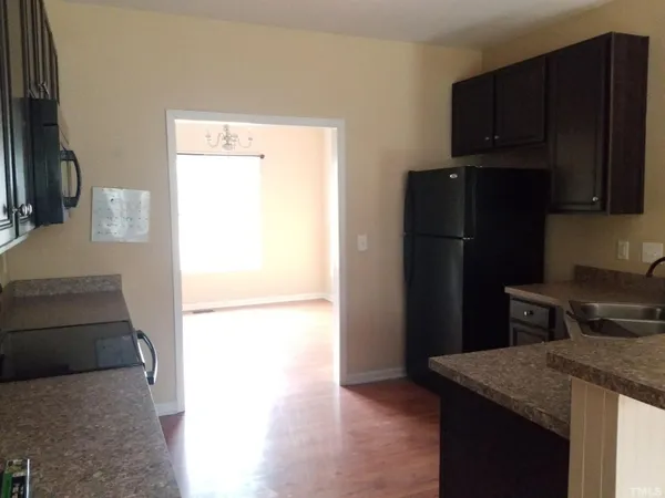 a kitchen with a refrigerator and a stove top oven