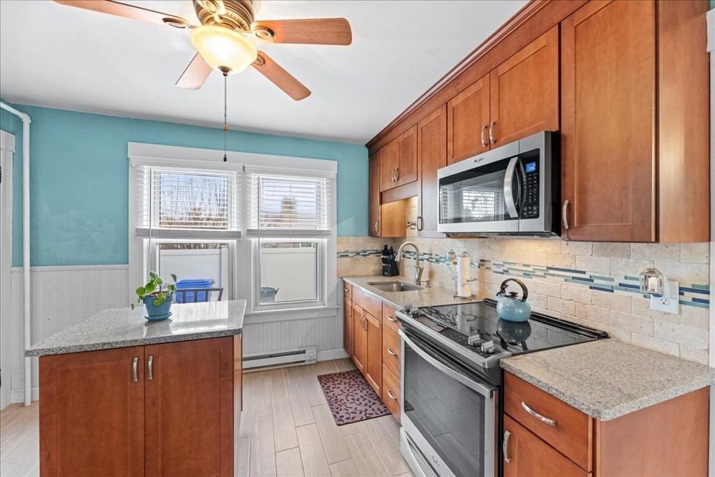 11 Mary Street Springfield, MA 01118 - Photo 9 of 42 a kitchen with stainless steel appliances granite countertop a sink a stove a refrigerator cabinets and furniture