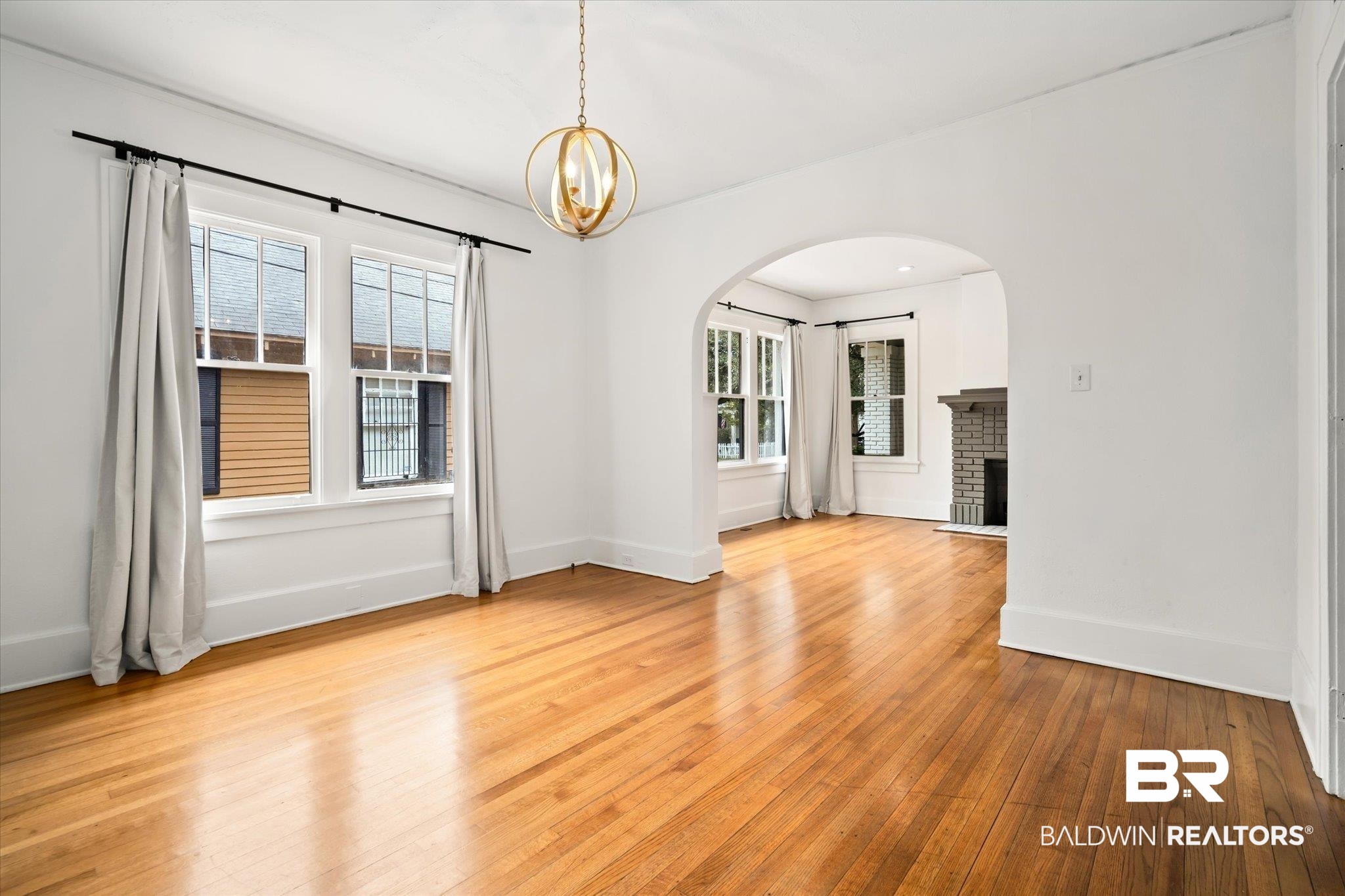308 South Ann Street Mobile, AL 36604 - Photo 7 of 30 Empty room with plenty of natural light, a brick fireplace, and light hardwood / wood-style flooring