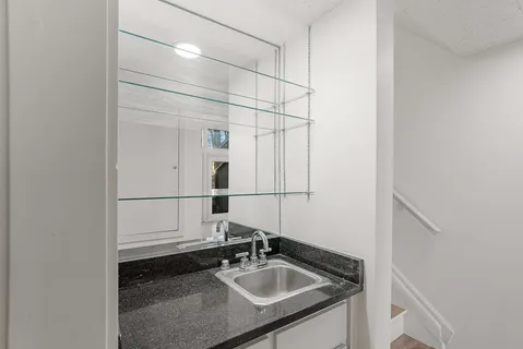 a bathroom with a granite countertop sink and a mirror