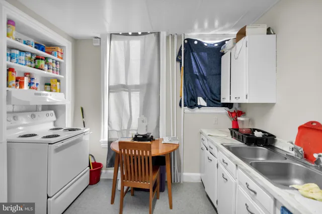 a kitchen with stainless steel appliances a white stove top oven a sink and a refrigerator