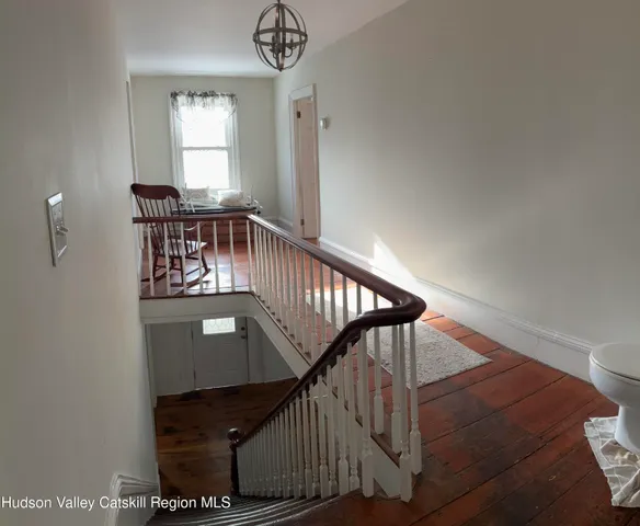 a view of entryway and hall with wooden floor