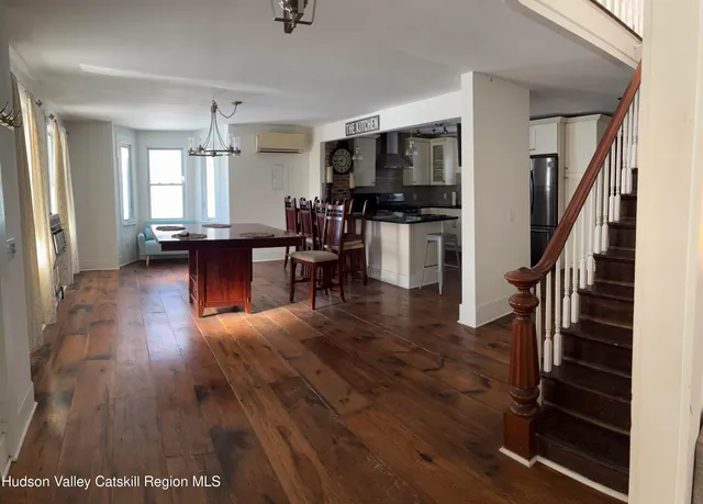 a living room with furniture floor to ceiling window and wooden floor