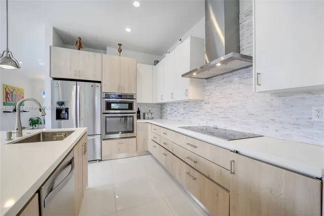 a kitchen with kitchen island a sink stainless steel appliances and cabinets
