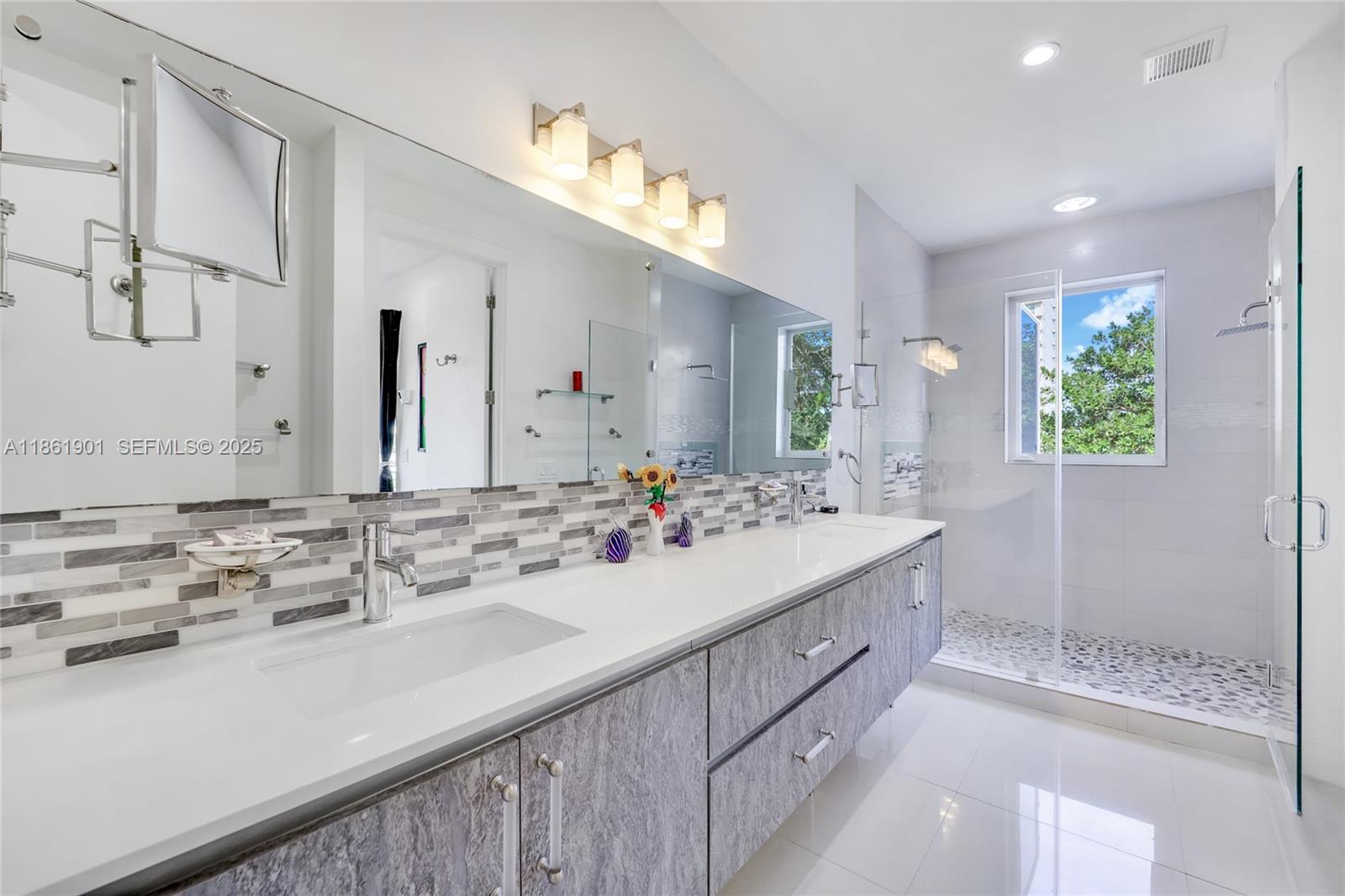 2943 Southwest 23rd Street Miami, FL 33145 - Photo 9 of 21 a bathroom with a sink double vanity granite tub shower and a mirror