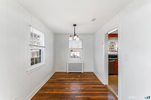 a hallway with wooden floor windows and entryway