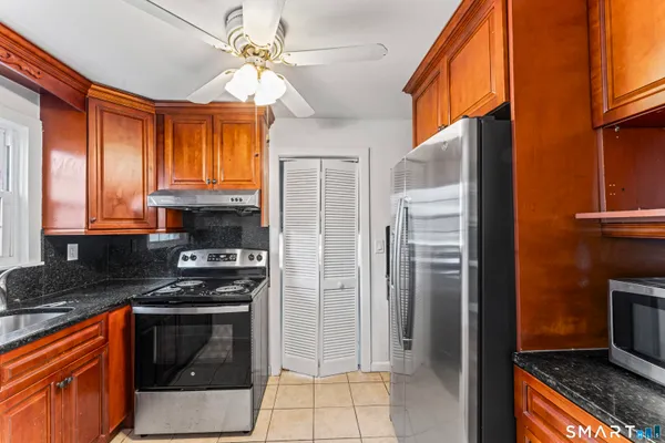a kitchen with stainless steel appliances granite countertop a stove a refrigerator and a sink