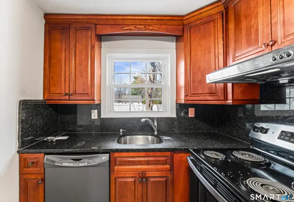 a kitchen with stainless steel appliances granite countertop a sink stove and cabinets