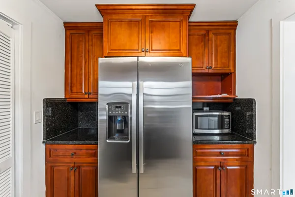 a kitchen with stainless steel appliances granite countertop a refrigerator and a stove