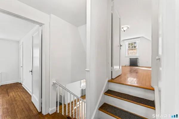 a room with wooden floor and a rug