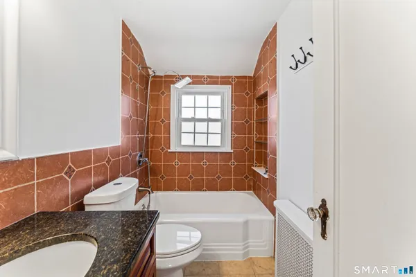 a bathroom with a granite countertop sink toilet and shower