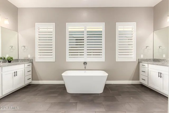 a spacious bathroom with a granite countertop tub sink and mirror