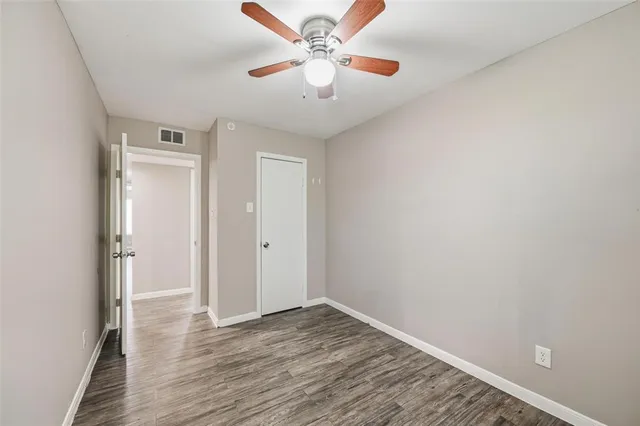 a view of an empty room and window a ceiling fan