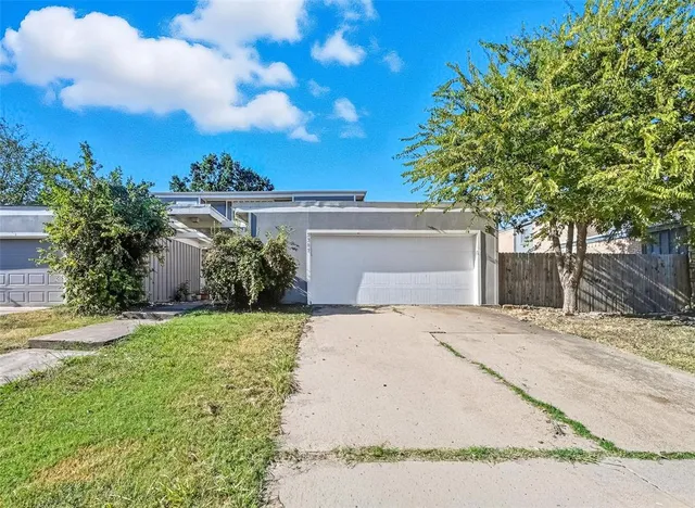 a front view of a house with a garden and trees