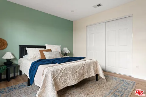a bed sitting in a bedroom next to a cabinet