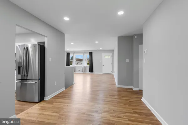 a view of a kitchen with a refrigerator and wooden floor