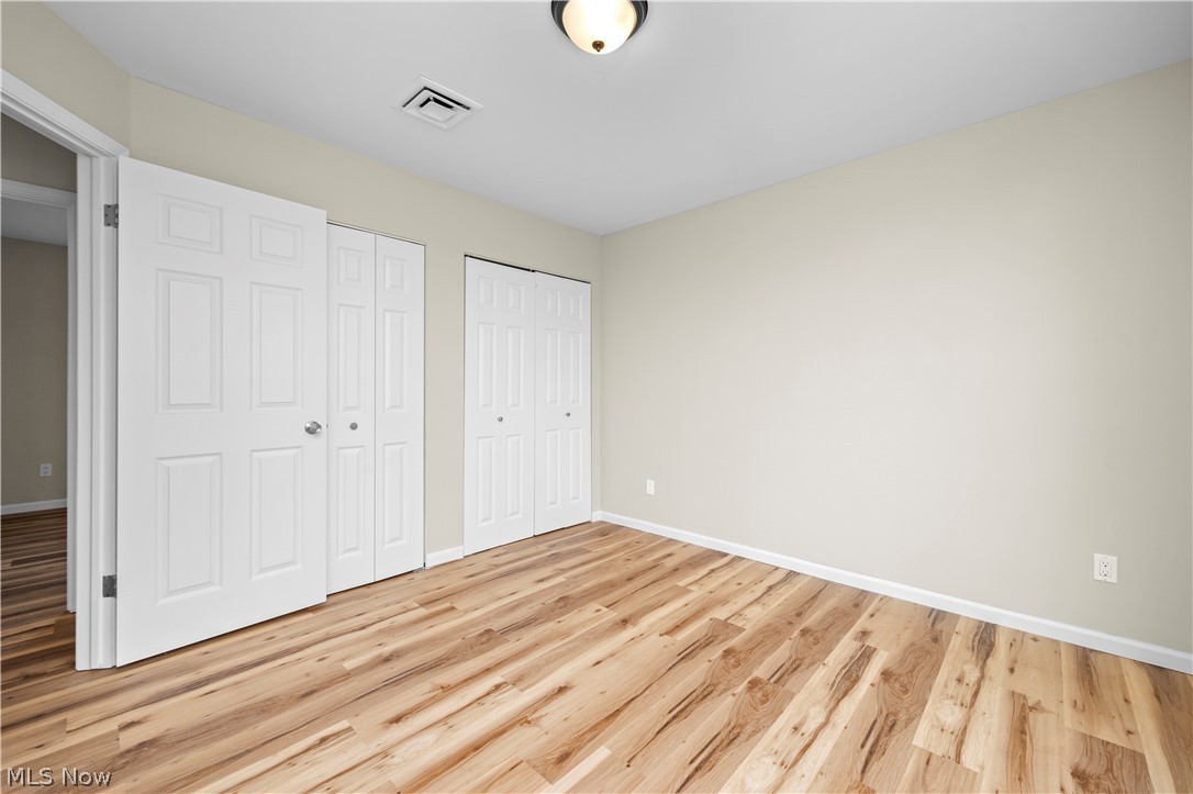 12452 Island Road Grafton, OH 44044 - Photo 18 of 39 Unfurnished bedroom featuring two closets and light wood-style floors