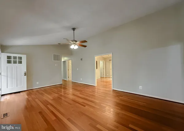 a view of an empty room with wooden floor