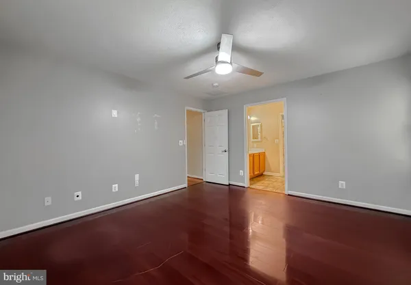 an empty room with a window and a ceiling fan
