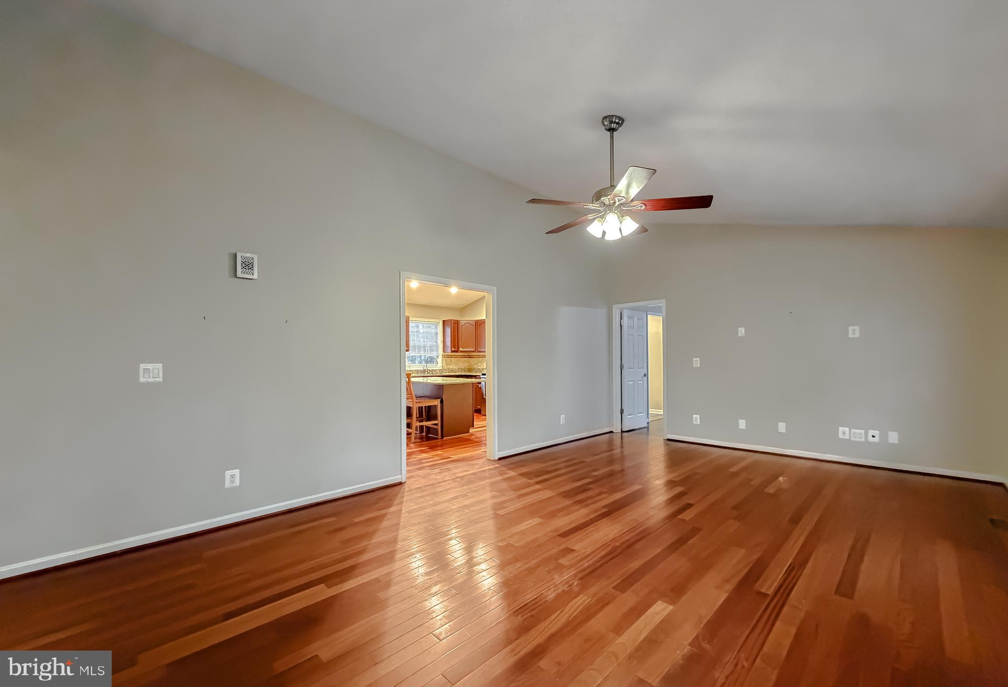 19830 Fall Court Great Mills, MD 20634 - Photo 4 of 47 a view of an empty room with wooden floor and a ceiling fan