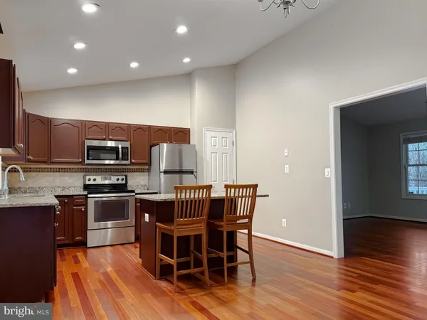 a view of a dining room with furniture a chandelier and wooden floor