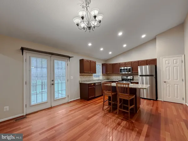 a kitchen with stainless steel appliances wooden floors and wooden cabinets