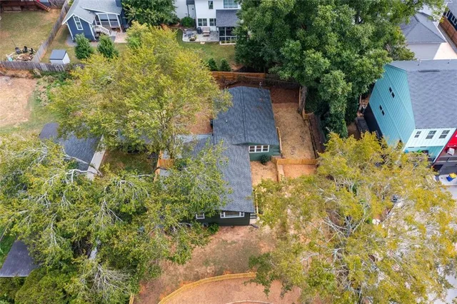 a backyard of a house with large trees and plants