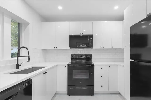 a kitchen with white cabinets and appliances
