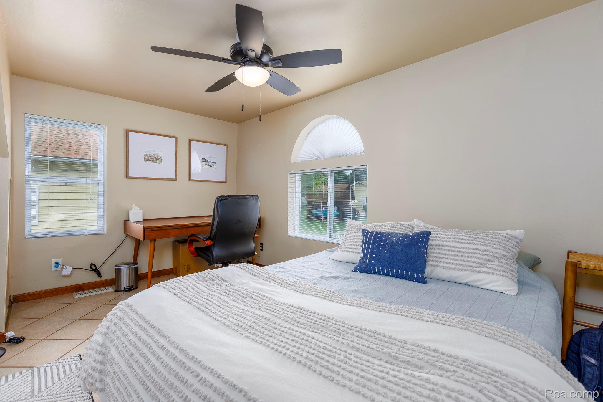 401 Pointe Tremble Road Algonac, MI 48001 - Photo 26 of 40 Room featuring an arched window, a rectangular window, beige wall tones, a ceiling fan with integrated lighting, and tile flooring