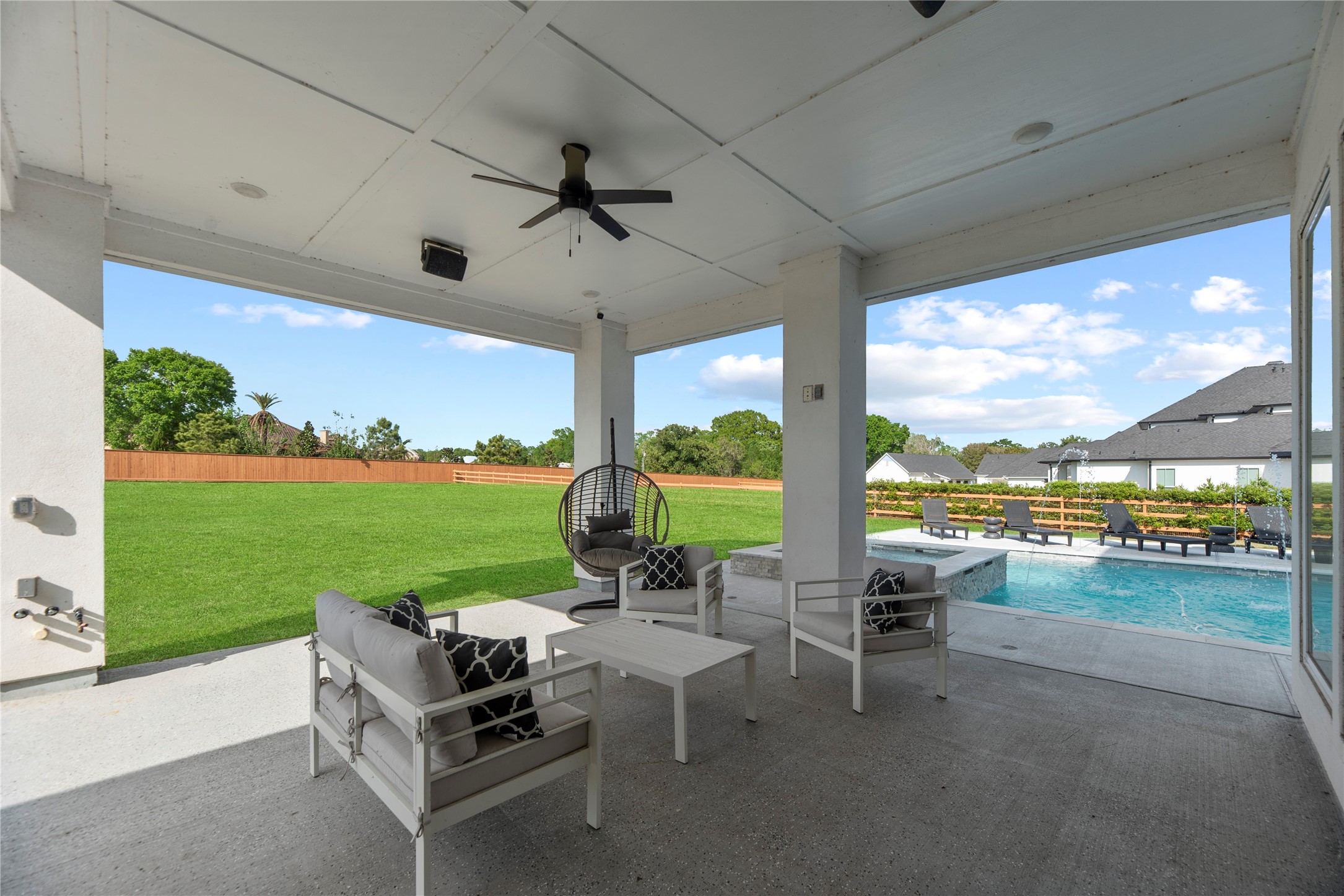 29526 Cir S Rnch Trail Fulshear, TX 77406 - Photo 35 of 47 Relax in style on the expansive covered patio, which features high ceilings, a cooling fan, and integrated outdoor speakers. This transition space offers a seamless indoor-outdoor lifestyle with direct views of the "dancing waters" in the pool area.
