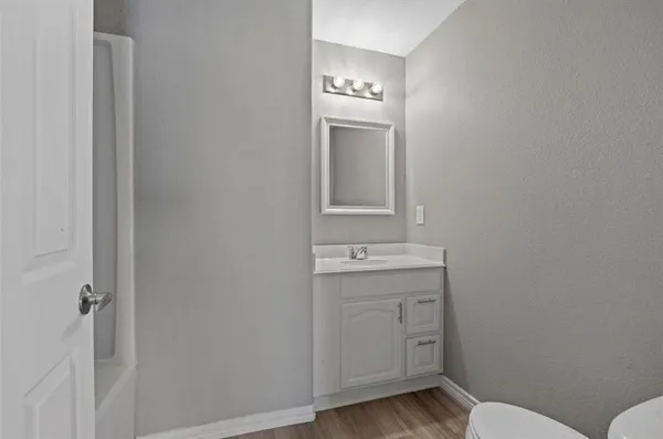 a bathroom with a toilet a sink and mirror
