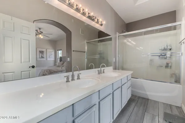 a bathroom with a double vanity sink a mirror and a bathtub