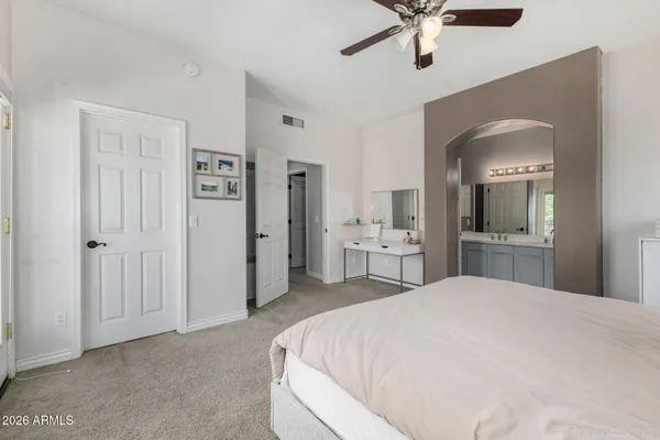 a large white bed in a white room with closet and mirror